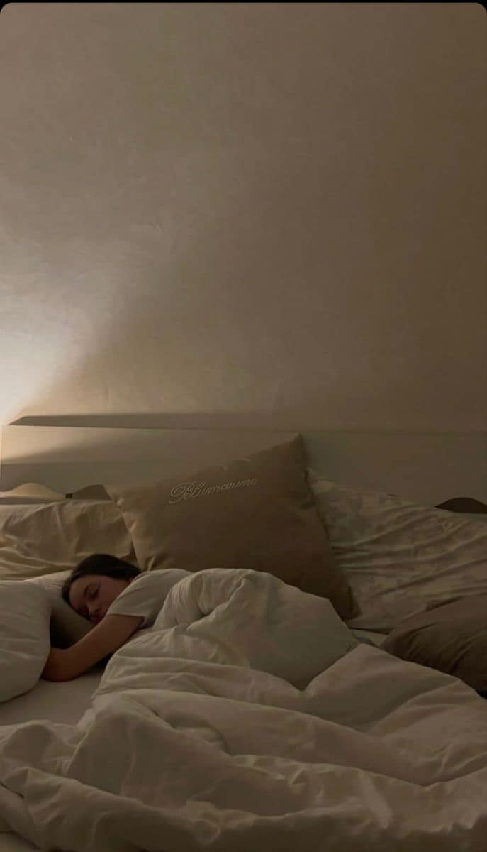 Woman sleeping peacefully in a dimly lit bedroom