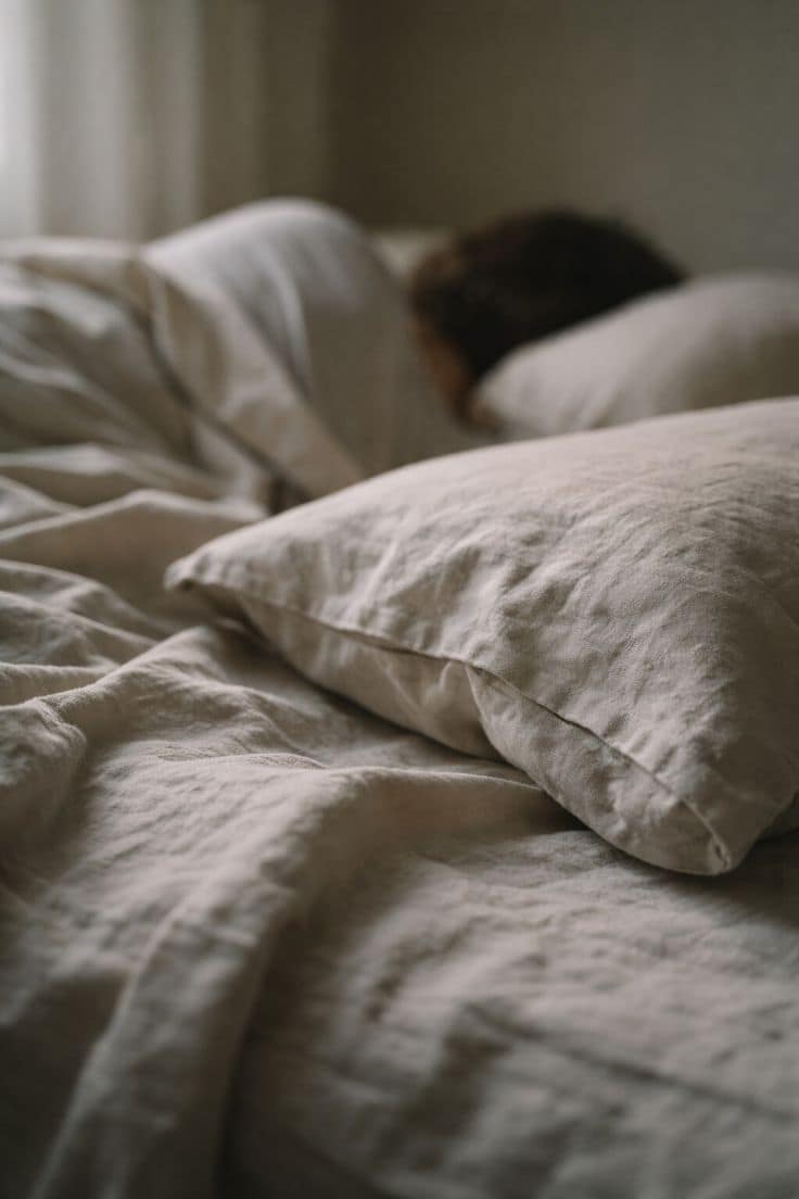 Person lying on a couch looking exhausted, staring at the ceiling in daylight