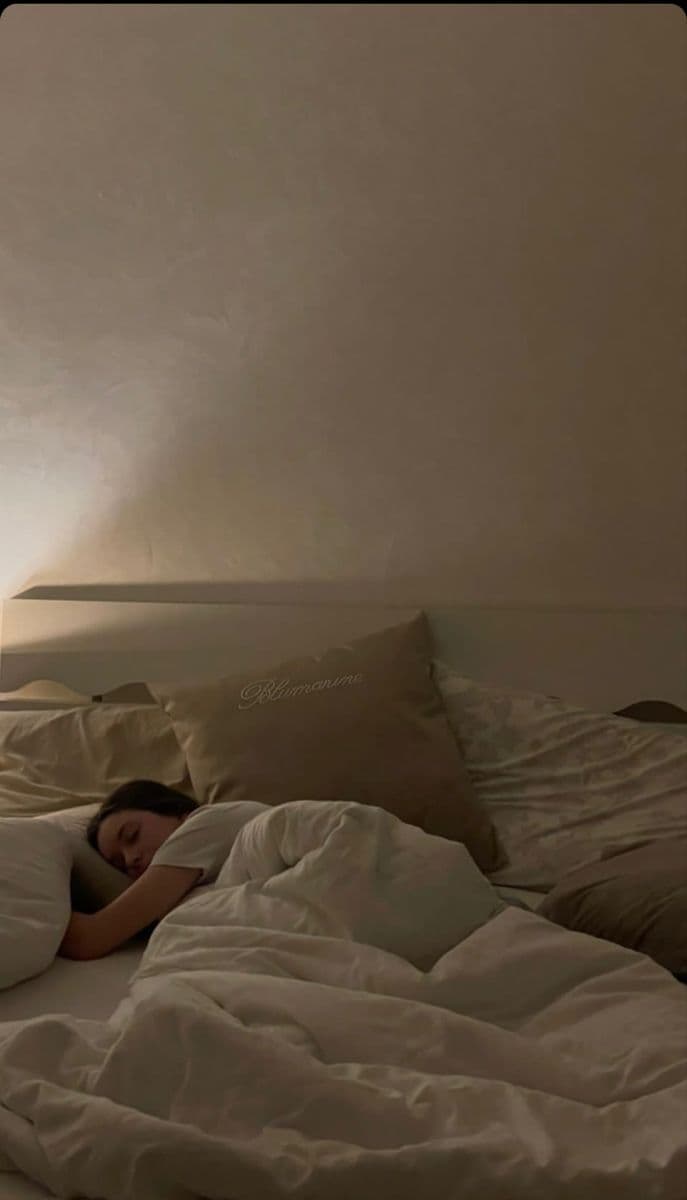 Woman sleeping peacefully in a dimly lit bedroom