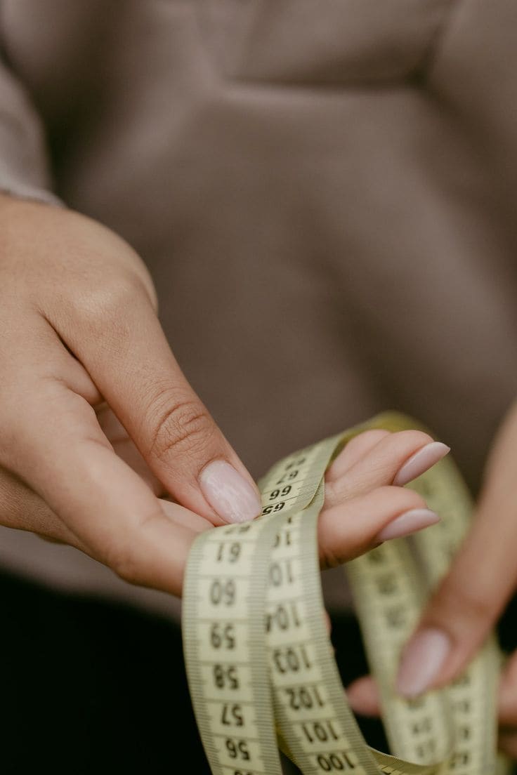 Cinta métrica enrollada sobre una superficie, símbolo de control del peso corporal