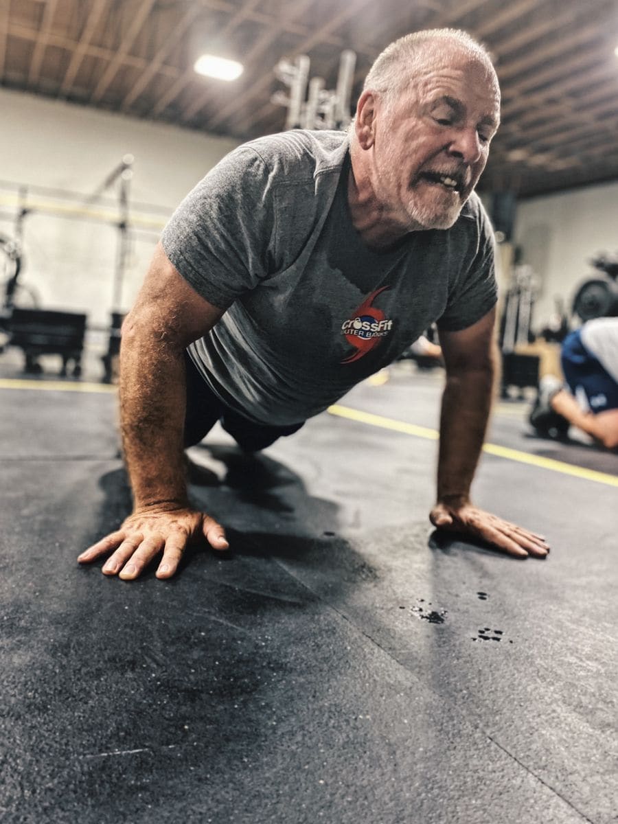 Older man exercising with weights to preserve muscle mass after 50