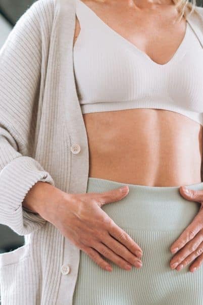Persona con síntomas de mala salud intestinal como hinchazón y fatiga