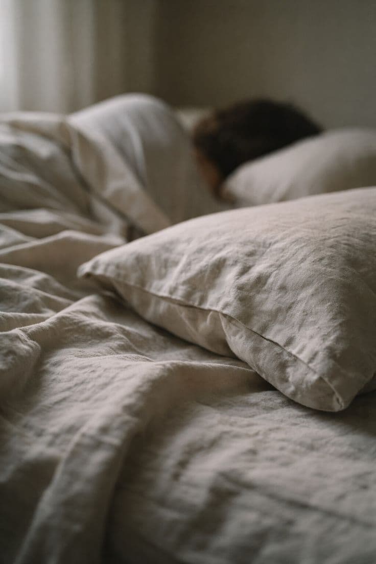 Person lying on a couch looking exhausted, staring at the ceiling in daylight
